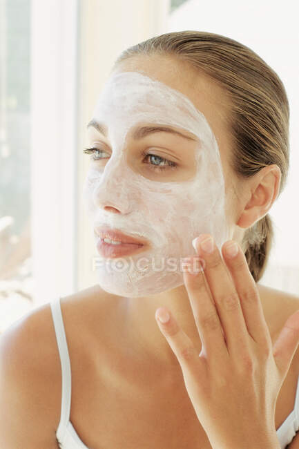 Mulher aplicando máscara facial — Fotografia de Stock