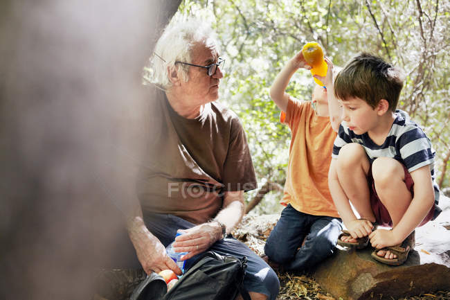 Padre y sus hijos jugando en el bosque - foto de stock