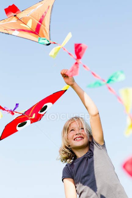 Девушка играет с воздушным змеем на открытом воздухе — стоковое фото