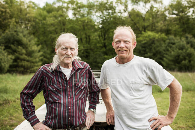 Vater und Sohn blicken in die Kamera, Porträt — Stockfoto