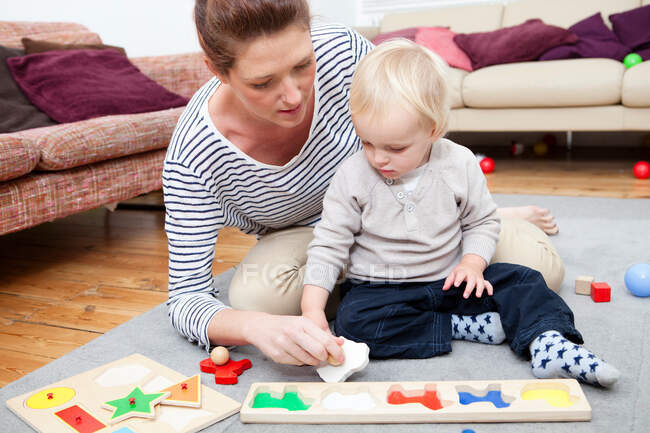 Mãe e filho brincando com quebra-cabeça — Fotografia de Stock