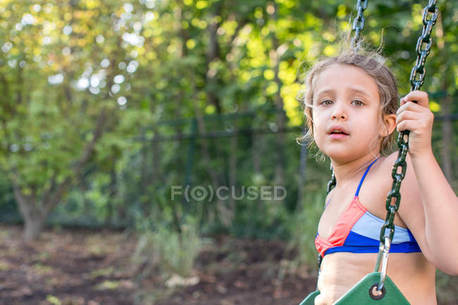 Дівчина гойдається на садовій гойдалці — стокове фото