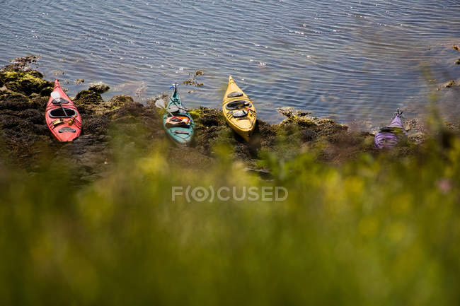 Kayaks docked on rocky beach — Stock Photo