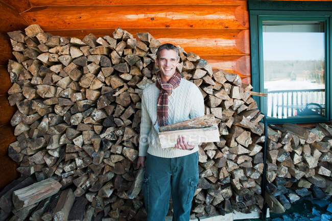 Hombre sosteniendo troncos, retrato - foto de stock