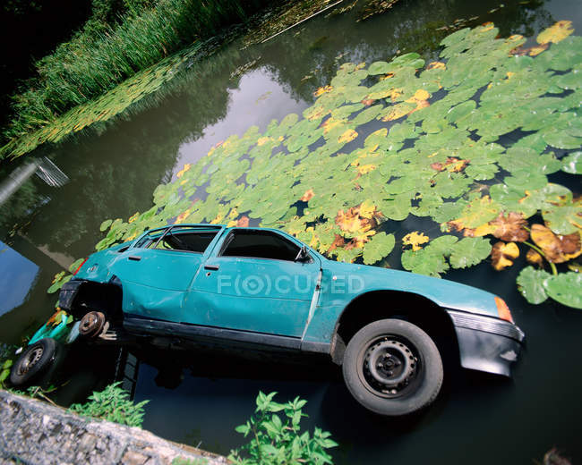 Broken car in pond — Stock Photo