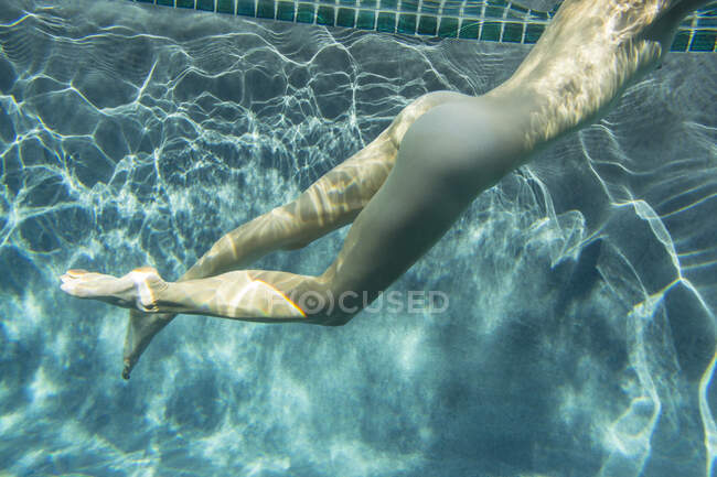 High angle underwater side view of nude young woman in swimming pool — Stock Photo