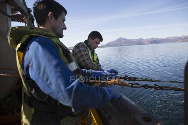 Pescador liberando red en el mar, Isla de Skye, Escocia - foto de stock