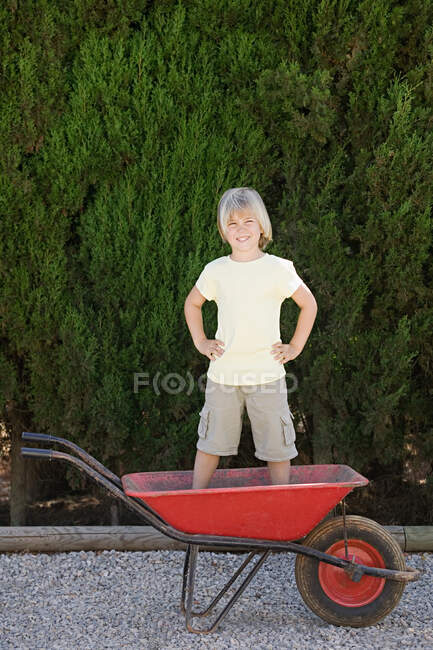 Мальчик стоит в тачке — стоковое фото