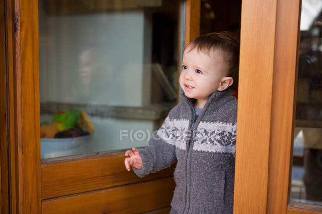 Jeune garçon à la porte du chalet — Photo de stock
