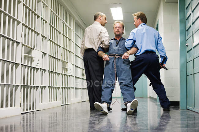В'язня тягнуть вниз коридор — стокове фото