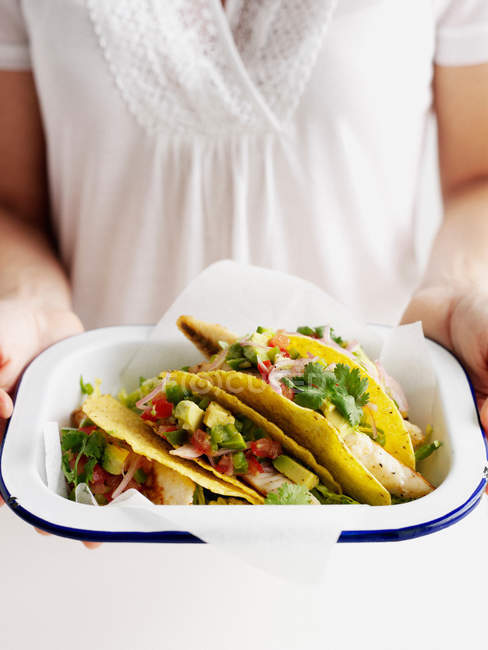 Woman holding bowl of fish tacos — Stock Photo