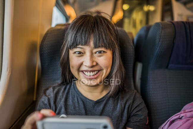 Портрет взрослой женщины в поезде, улыбающейся в камеру — стоковое фото