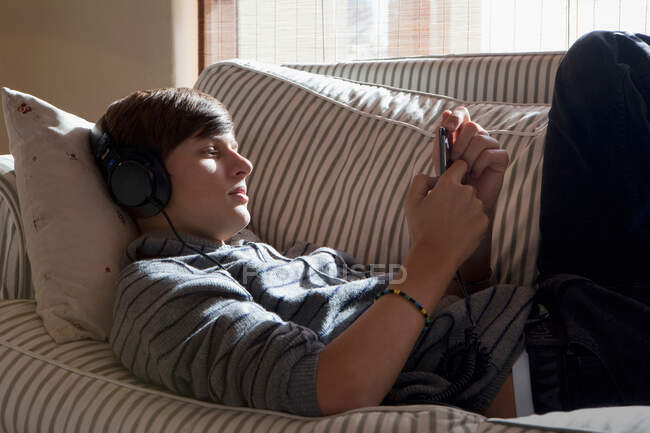 Adolescent garçon écoute écouteurs — Photo de stock