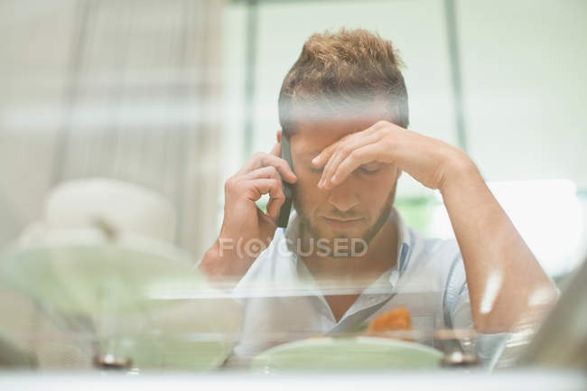 Man talking on cell phone at breakfast — Stock Photo
