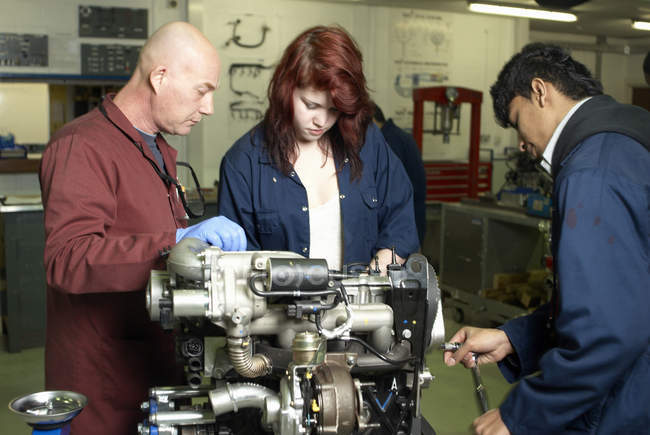 Teacher helping students with car engine — Stock Photo