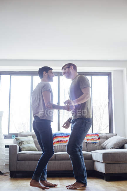 Мужская пара дома, танцуют вместе, лицом к лицу — стоковое фото