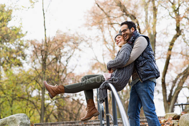 Couple étreignant sur la rampe du parc — Photo de stock