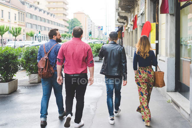 Grupo de amigos caminhando juntos na calçada — Fotografia de Stock