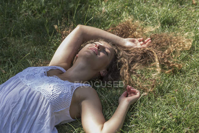 Дівчина-підліток лежить на траві і посміхається — стокове фото