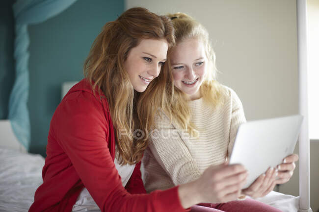 Zwei Teenager schauen im Schlafzimmer auf digitales Tablet — Stockfoto