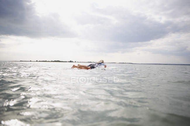 Donna anziana su tavola da surf in mare, paddleboarding — Foto stock