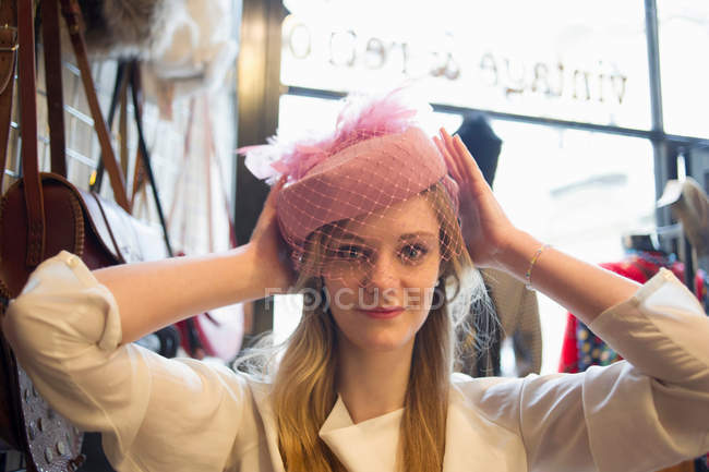 Mujer probándose un sombrero vintage - foto de stock