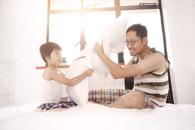 Cinese padre e figlio avendo un cuscino lotta — Foto stock