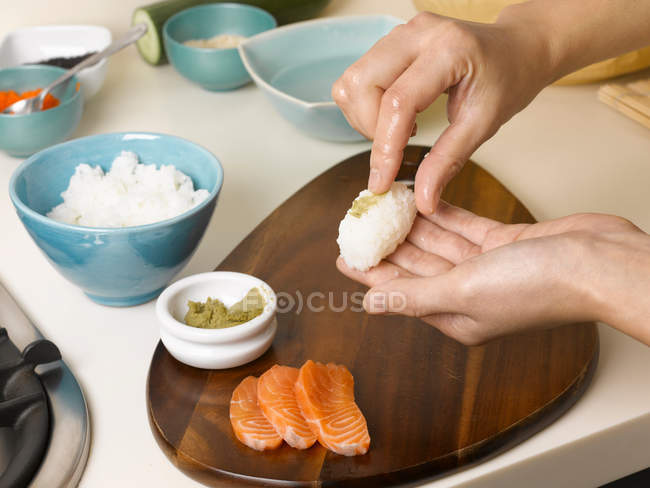 Femme préparant des sushis à table — Photo de stock