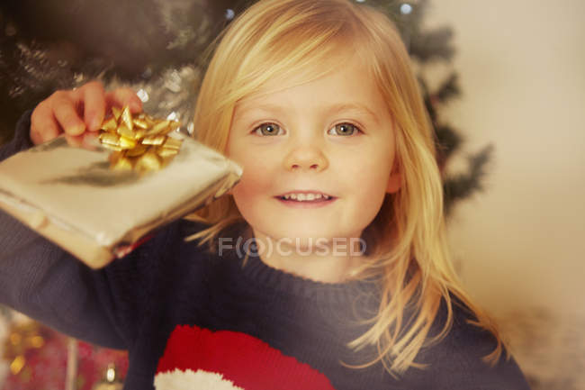 Young girl holding Christmas present — Stock Photo