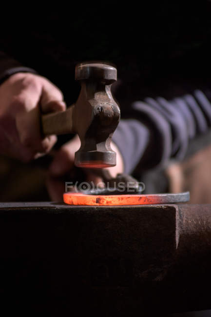 Farrier forging horseshoe on anvil — Stock Photo