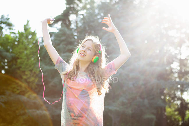 Teenage girl listening to mp3 player and dancing — Stock Photo