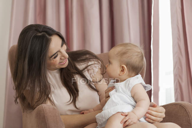 Mãe brincando com bebê em poltrona — Fotografia de Stock