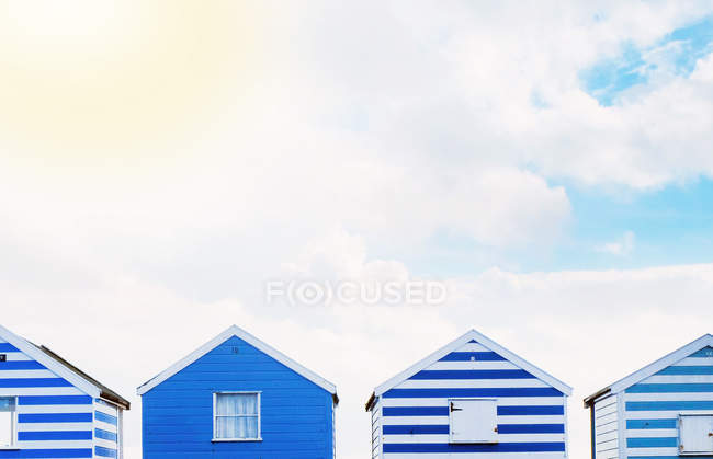 Fila de coloridas cabañas de playa durante el día, Suffolk, Reino Unido - foto de stock