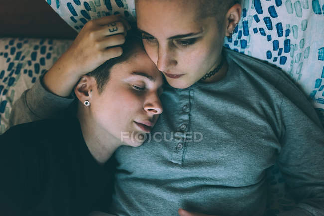 Blick aus der Vogelperspektive auf junges lesbisches Paar, das auf Bett liegt — Stockfoto