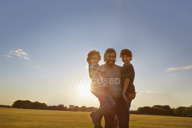 Отец выносил сыновей в солнечный парк — стоковое фото