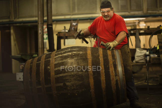 Mature man making whisky cask in cooperage — Stock Photo