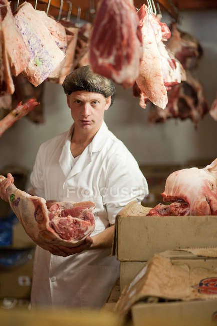 Portrait of butcher holding raw meat — Stock Photo