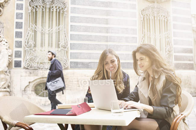 Две молодые женщины смотрят на ноутбук возле Музея Серсеи, Валенсия, Испания — стоковое фото