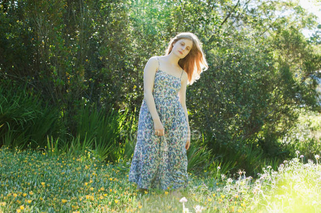 Ragazza adolescente in piedi nel campo dei fiori — Foto stock