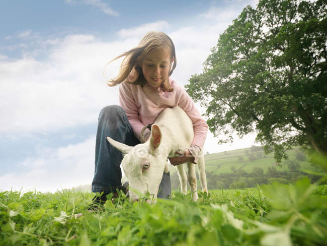 Девушка держит козу на ферме — стоковое фото