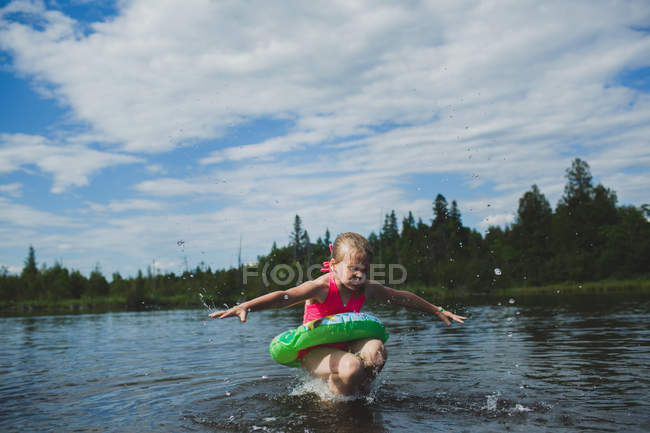 Ragazza con anello di gomma che salta nel fiume Indiano, Ontario, Canada — Foto stock