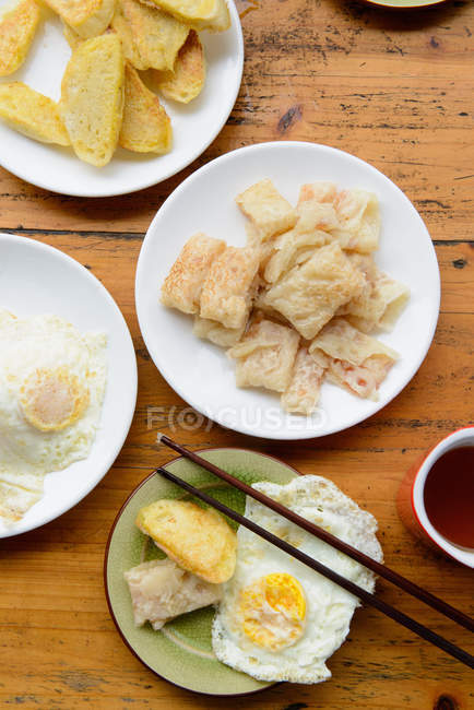 Vista dall'alto di piatti di uova fritte e pasticceria sul tavolo — Foto stock