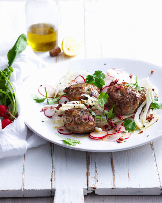 Plate of meatballs with radishes — Stock Photo
