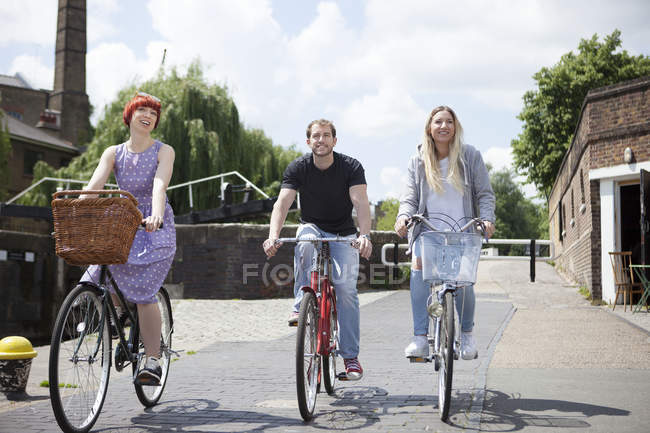 Friends riding bikes along canal, London, UK — Stock Photo
