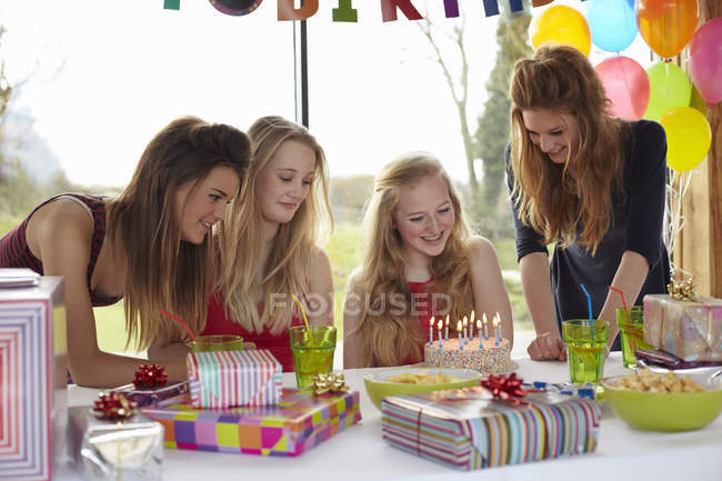 Adolescente chica compartir pastel de cumpleaños con amigos - foto de stock