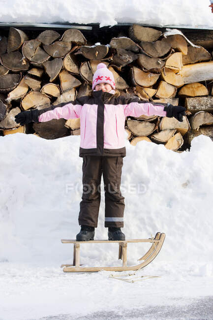 Junges Mädchen steht auf Schlitten — Stockfoto