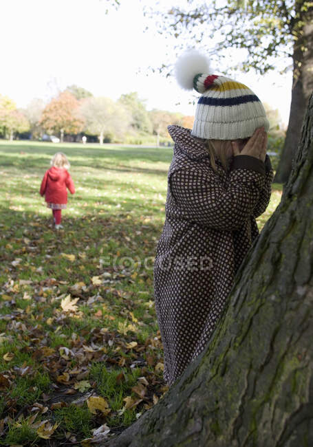 Chicas jugando al escondite en Park, Londres, Inglaterra, Reino Unido - foto de stock