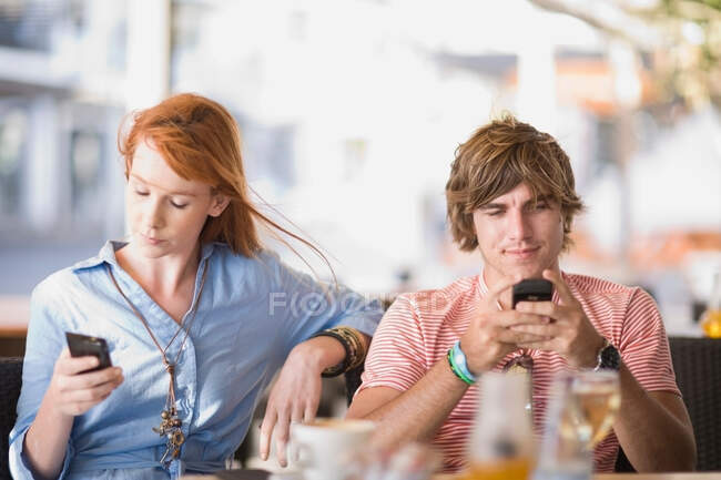 Мужчина и женщина пишут смс — стоковое фото