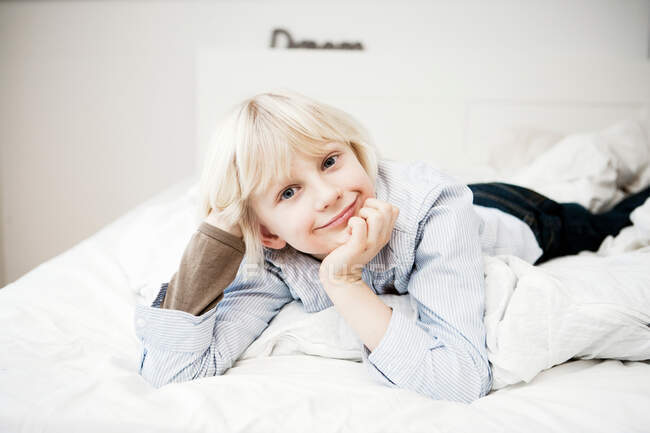 Porträt eines kleinen Jungen, der auf dem Bett liegt — Stockfoto