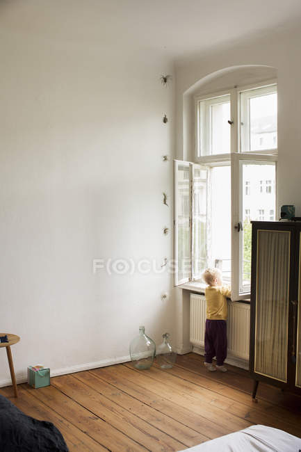 Baby girl looking out of window, rear view — Stock Photo